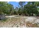 Large backyard with trees, outbuildings and a cleared sand area at 1560 7Th Ave, Deland, FL 32724