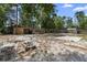 Spacious backyard with sandy ground cover and brick fire pit, perfect for enjoying cozy evenings outdoors at 1560 7Th Ave, Deland, FL 32724