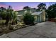 Two-story home with a yellow and green exterior, a metal roof, a brick trim, and a concrete driveway at 1560 7Th Ave, Deland, FL 32724