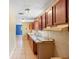 Traditional kitchen with wood cabinets, tile backsplash, double sink, and tile flooring at 1560 7Th Ave, Deland, FL 32724
