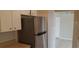 Kitchen view showcases stainless steel refrigerator, white cabinets and tile flooring at 1626 S Page Dr, Deltona, FL 32725