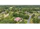 Aerial view of home nestled among lush trees with golf course views, pool, and serene setting at 1641 Timber Hills Dr, Deland, FL 32724