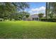 Expansive backyard featuring lush green grass, mature trees, and a screened-in patio, perfect for outdoor enjoyment at 1641 Timber Hills Dr, Deland, FL 32724