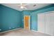 Blue-walled bedroom featuring carpet, a ceiling fan, white closet doors, and an open doorway at 1641 Timber Hills Dr, Deland, FL 32724