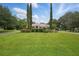 Expansive green lawn and meticulously landscaped front yard featuring tall, slender trees that frame the home at 1641 Timber Hills Dr, Deland, FL 32724
