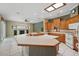 Spacious kitchen with wooden cabinets, a large island counter, and an open view into the living area with a fireplace at 1641 Timber Hills Dr, Deland, FL 32724