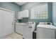Well-lit laundry room with a utility sink, white cabinets, modern appliances, and a window at 1641 Timber Hills Dr, Deland, FL 32724