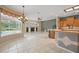 Open-concept living space with tile flooring, a fireplace, neutral and green walls, and an adjacent kitchen area at 1641 Timber Hills Dr, Deland, FL 32724