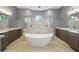 A modern main bathroom with separate vanities, walk-in shower, and freestanding soaking tub at 1641 Timber Hills Dr, Deland, FL 32724