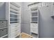 A walk-in closet with drawers and shelving is seen with gray walls and wood-style flooring at 1641 Timber Hills Dr, Deland, FL 32724
