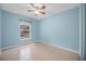A serene bedroom with a ceiling fan and a window overlooking a lush outdoor scene at 1890 15Th St, Orange City, FL 32763