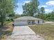 Aerial view of a well-maintained single story house with an attached two-car garage and mature trees at 1890 15Th St, Orange City, FL 32763
