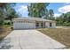 Front exterior of a single story home with a large driveway at 1890 15Th St, Orange City, FL 32763