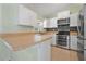 Well-equipped kitchen with white cabinets, stainless steel appliances, a window, and a breakfast bar at 1890 15Th St, Orange City, FL 32763