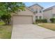 Two story home featuring a large garage, neutral paint and well maintained landscaping in a suburban neighborhood at 1922 Cove Point Rd, Port Orange, FL 32128