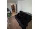 Simple bedroom featuring neutral walls, carpet flooring, and black bedding, leading to another room at 2219 Howland Blvd, Deltona, FL 32738