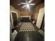 Eclectic living space featuring a futon, decorative rug, ceiling fan, and plywood walls at 2219 Howland Blvd, Deltona, FL 32738