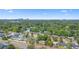 An aerial view showing a dense community with a lake and distant city buildings at 2327 Mulbry Dr, Winter Park, FL 32789