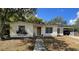 Charming single-story home featuring a cozy front porch and an adjacent car port, surrounded by mature trees at 2332 Hadley St, Deltona, FL 32738