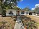Charming single-story home featuring a cozy front porch and an adjacent car port, surrounded by mature trees at 2332 Hadley St, Deltona, FL 32738