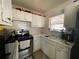 A bright kitchen with white cabinetry, vintage tile backsplash and stainless steel oven range at 2332 Hadley St, Deltona, FL 32738