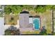 An aerial view of a home featuring a pool, screened lanai, roof and driveway at 2416 Candlewick St, Deltona, FL 32738
