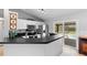 This kitchen features black counters, white cabinets, and stainless steel appliances, with pool views at 2416 Candlewick St, Deltona, FL 32738