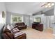 Cozy living room featuring tile floors, a ceiling fan, comfortable leather sofas, and an entertainment center at 2416 Candlewick St, Deltona, FL 32738