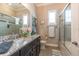 Elegant bathroom featuring granite countertops, dual sinks, a glass-enclosed shower, and natural light, creating a spa-like experience at 2435 Pawtucket Pass, Mount Dora, FL 32757