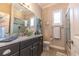 Elegant bathroom featuring granite countertops, dual sinks, a glass-enclosed shower, and natural light, creating a spa-like experience at 2435 Pawtucket Pass, Mount Dora, FL 32757