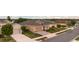 View of the house featuring tan siding, stone accents, an attached garage, and verdant front yard at 2435 Pawtucket Pass, Mount Dora, FL 32757