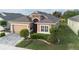 Single-story home boasts a manicured lawn, tasteful landscaping, and a welcoming entryway at 2435 Pawtucket Pass, Mount Dora, FL 32757