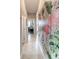 Hallway featuring neutral walls, decorative flamingo art, tile flooring, and an archway leading into another room at 2435 Pawtucket Pass, Mount Dora, FL 32757