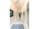 Inviting hallway featuring neutral walls, decorative art, a stylish light fixture, and tiled flooring, creating a welcoming ambiance at 2435 Pawtucket Pass, Mount Dora, FL 32757