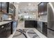 Stylish kitchen featuring dark cabinetry, stainless steel appliances, and granite countertops at 2435 Pawtucket Pass, Mount Dora, FL 32757