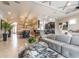 Bright living room with gray sofa, glass coffee table, and open layout to dining and kitchen at 2435 Pawtucket Pass, Mount Dora, FL 32757