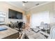 Bright office with desk, large screen TV, comfortable chair, and neutral-toned walls at 2435 Pawtucket Pass, Mount Dora, FL 32757