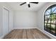 Bedroom with wood flooring, arched window and ceiling fan at 245 Rosita Dr, Debary, FL 32713