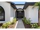 Arched front door with sidelights and decorative plants leading to a welcoming entrance at 245 Rosita Dr, Debary, FL 32713