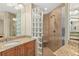 Well-lit bathroom showcases a granite vanity, glass block partition, and tiled shower with bench at 2515 S Atlantic Ave # 1001, Daytona Beach Shores, FL 32118