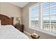 Bedroom showcasing a view with plantation shutters, side table, and comfortable bed at 2515 S Atlantic Ave # 1001, Daytona Beach Shores, FL 32118