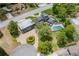 A unique home aerial featuring a circular drive, mature trees, and a beautiful home exterior with a sparkling pool at 2551 Cross Country Dr, Port Orange, FL 32128