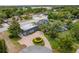 Aerial view of a home with a large, flat-roofed addition, pool, and circular driveway at 2551 Cross Country Dr, Port Orange, FL 32128