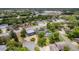 Aerial view of a beautiful property with a circular driveway, mature trees, and a screened-in pool at 2551 Cross Country Dr, Port Orange, FL 32128