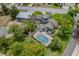 A beautiful aerial view of a custom home featuring a screened pool, lush landscaping, and architectural details at 2551 Cross Country Dr, Port Orange, FL 32128