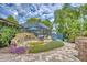 Backyard featuring a screened-in pool area, pond with waterfall, and brick-paved patio at 2551 Cross Country Dr, Port Orange, FL 32128