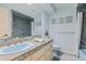 Serene bathroom featuring a classic vanity, vibrant tiled shower, and complementary blue fixtures at 2551 Cross Country Dr, Port Orange, FL 32128