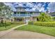 Stunning two-story home featuring a brick facade, balcony, lush landscaping, and inviting entrance at 2551 Cross Country Dr, Port Orange, FL 32128
