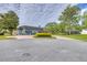 Spacious brick driveway, lush landscaping, and blue building under a cloudy sky at 2551 Cross Country Dr, Port Orange, FL 32128