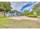 Expansive brick driveway leading to a blue building surrounded by lush greenery at 2551 Cross Country Dr, Port Orange, FL 32128